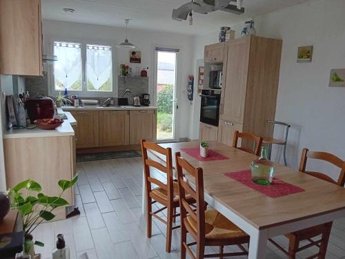 Il comprend une cuisine avec une table en bois, des chaises et une table. dans l'établissement Gîte Sèvremoine Bois Buteau, à Montfaucon