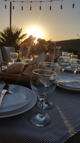 a table with plates and wine glasses on it at Hotel and Restaurant "VILLA GIVISI" in Lagodekhi