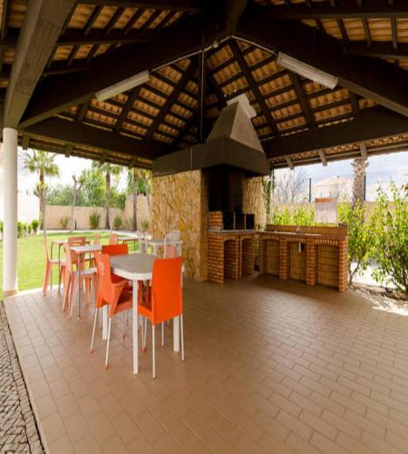 a patio with a table and chairs and a stove at Jardins de Pêra in Pêra