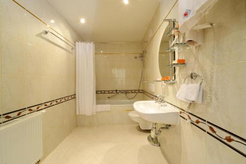 a bathroom with a sink and a toilet and a tub at Narantuul Hotel in Ulaanbaatar