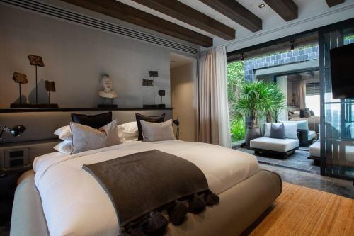 a bedroom with a large bed and a living room at Villa Saru Sea View Luxury Villa in Koh Samui 