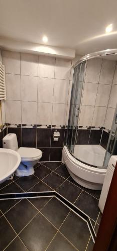 a bathroom with a tub and a toilet and a sink at Apartament Sosnowiec in Sosnowiec