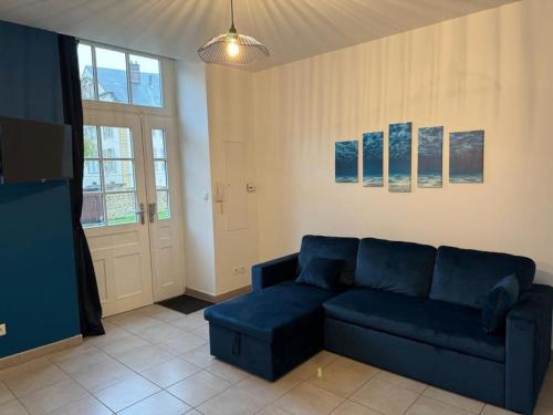 ein Wohnzimmer mit einem blauen Sofa und einem TV in der Unterkunft Appartement d'une chambre avec terrasse et wifi a Sedan in Sedan