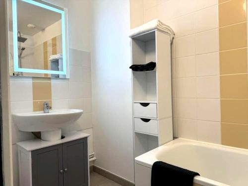ein Badezimmer mit einem Waschbecken und einer Badewanne in der Unterkunft Appartement d'une chambre avec terrasse et wifi a Sedan in Sedan