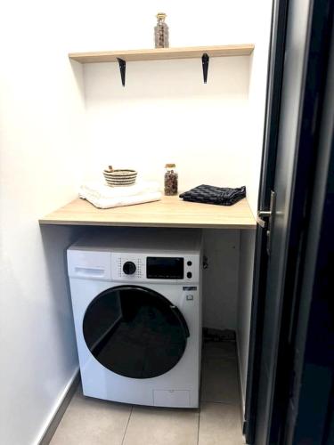 eine Waschmaschine und einen Trockner unter einer Theke in einer Küche in der Unterkunft Appartement d'une chambre avec terrasse et wifi a Sedan in Sedan