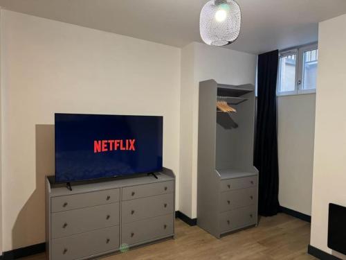 einen TV auf der Kommode in einem Zimmer in der Unterkunft Appartement d'une chambre avec terrasse et wifi a Sedan in Sedan