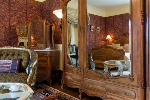 a bedroom with a large wooden cabinet with a mirror at Harrisons Hall Bed & Breakfast in Mold