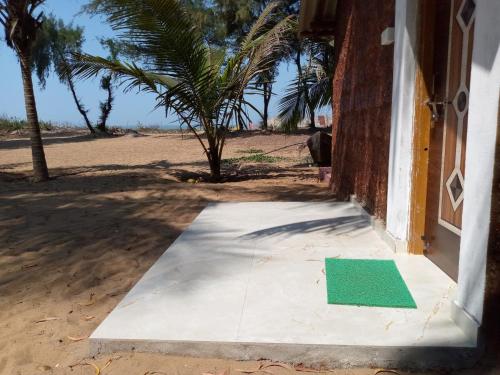Gopal beach house في كاروار: باب مع أرضية خضراء خارج المبنى