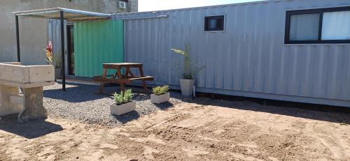 a patio with a table and potted plants next to a building at Alojamientos Dulce Luz in Villa Elisa