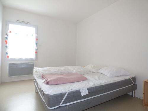 - un lit avec une couverture rose dans une chambre dans l'établissement La Balise, à Saint-Gilles-Croix-de-Vie