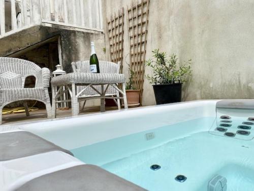 una vasca idromassaggio sul patio con una bottiglia di vino di Les Vagues a Saint-Gilles-Croix-de-Vie