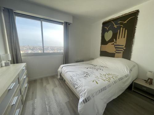 une chambre avec un lit et une grande fenêtre dans l'établissement Le Rêve bleu, à Saint-Gilles-Croix-de-Vie