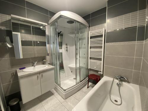 La salle de bains est pourvue d'une baignoire, d'un lavabo et d'une douche. dans l'établissement Splendide roof top au pied de la grande plage, à Saint-Gilles-Croix-de-Vie
