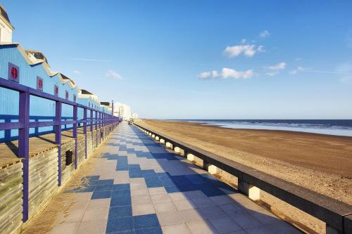 une plage avec une clôture bleue et l'océan dans l'établissement L'océania Joli studio 3 personnes au pied de la Grande plage, à Saint-Gilles-Croix-de-Vie