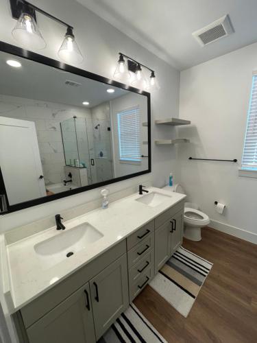 baño con lavabo y espejo grande en Modern Townhouse, en Addison