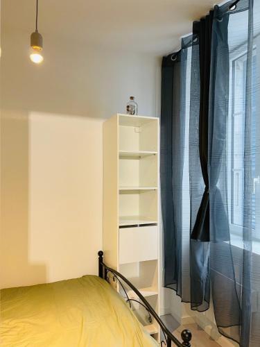 une chambre avec un lit et une fenêtre dans l'établissement LE CAUBOUS Plein centre Appartement calme avec chambre et cuisine équipée, à Bagnères-de-Bigorre
