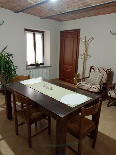 a dining room with a wooden table and chairs at Le vigne in Asti