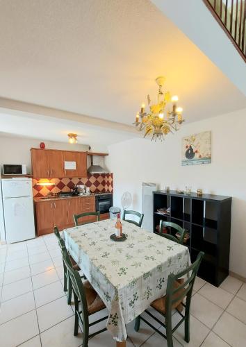 une cuisine et une salle à manger avec une table et des chaises dans l'établissement soleil catalan terrasse panoramique ok chéques vacances animaux 4pers wifi 65m2 jardin parking 2ch 2km mer, à Latour-Bas-Elne