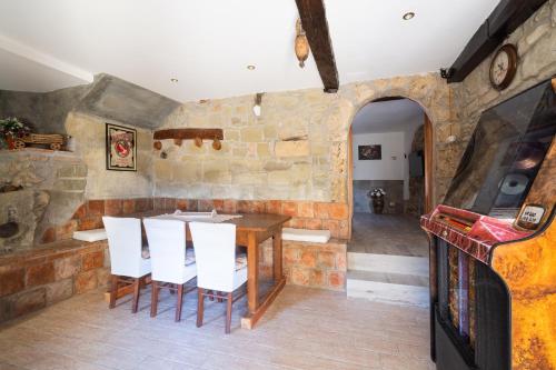 a dining room with a table and white chairs at Casa Vacanze “Rocca dei sogni” in Aquasanta