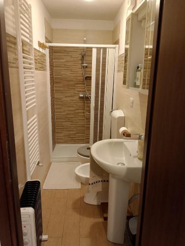 a white bathroom with a toilet and a sink at Le vigne in Asti