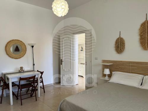 a bedroom with a bed and a table and a desk at Casa Mireya - Spiaggia a 50m - by Cala Salento in Porto Cesareo