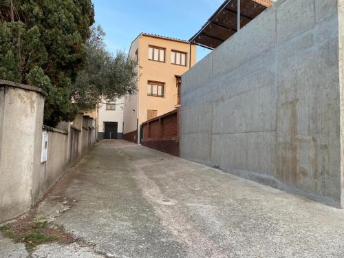 an empty alley with a concrete wall and a building at Can Pirrot Salitja in Salitja