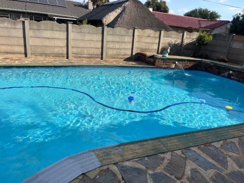 a swimming pool with blue water in a yard at House 210 holiday rentals in Alberton