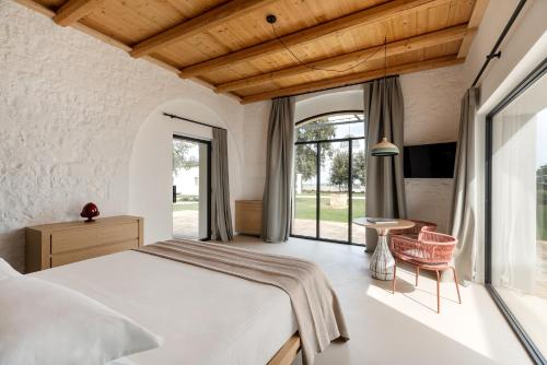 um quarto com uma cama e uma grande janela em Tenuta Castione em Polignano a Mare