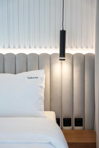 a bedroom with a white bed and a black lamp at Volos Inn Hotel in Volos