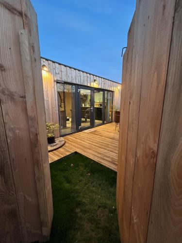 a view of a wooden deck from the outside of a house at L'atelier de la clef des Paons in Luc-sur-Mer