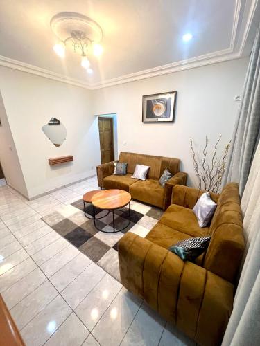 a living room with a couch and a table at Hacienda Residence - Solar Energized in Yaoundé