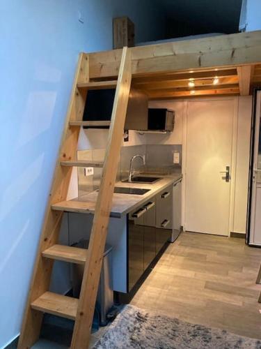 une cuisine avec un escalier menant à un loft dans l'établissement Tiny house avec terrasse, à Versailles