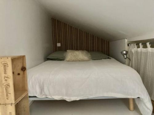 sypialnia z białym łóżkiem z drewnianym zagłówkiem w obiekcie Tiny house avec terrasse w Wersalu