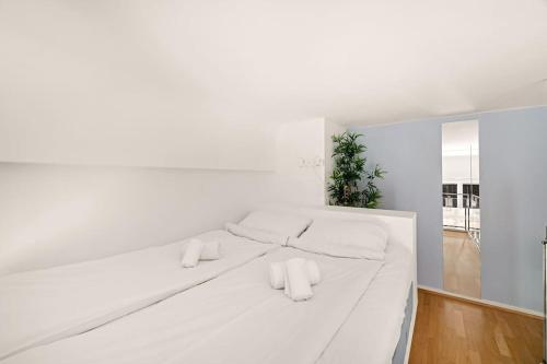 Una cama blanca con dos almohadas blancas. en Dinbnb Apartments I 500m to Oslo Central Station I Roof Terrace I Free Gym, en Oslo