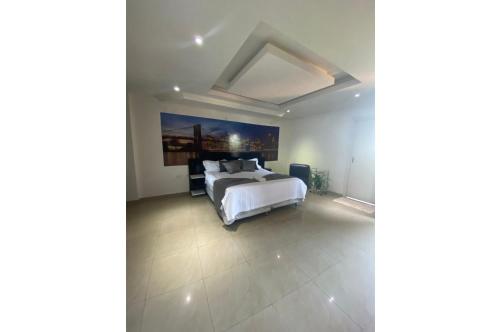 um quarto com uma cama e um quadro na parede em Departamento amplio y completo en Área 8 p/ 6 pers em Ciudad del Este