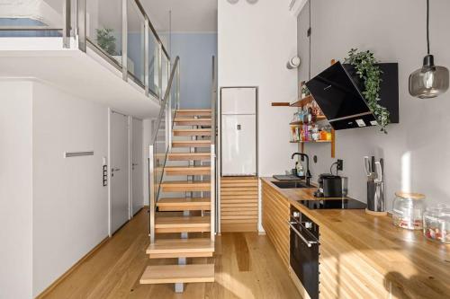 escalera en una cocina con paredes blancas y suelo de madera en Dinbnb Apartments I 500m to Oslo Central Station I Roof Terrace I Free Gym, en Oslo