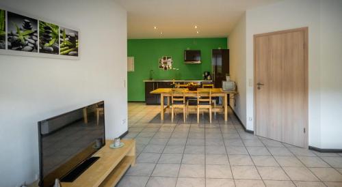 a living room with a table and a green wall at Moseltraum in Bruttig-Fankel