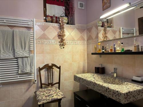 un bagno con lavandino e sedia di Vill'Ariel Sport & Relax a Brovello-Carpugnino