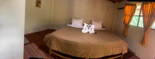 Un dormitorio con una cama con zapatos blancos. en Refugio de Mery Lucmabamba, en Sahuayacu