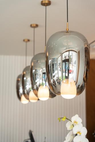 a row of chandeliers with white flowers in a vase at Volos Inn Hotel in Volos