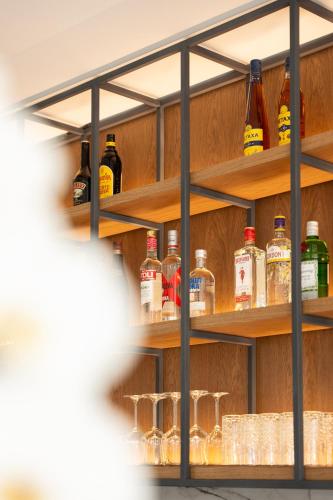 a shelf with alcohol bottles and glasses on it at Volos Inn Hotel in Volos