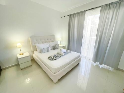 ein weißes Schlafzimmer mit einem Bett und einem Fenster in der Unterkunft studio on the beach beautiful view in Punta Cana