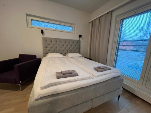 a bedroom with a bed and a chair and a window at Saunallinen keskustayksiö ja ilmainen yksityinen parkkipaikka in Turku