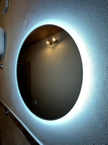 a round mirror on a wall in a bathroom at Villa Sibilla in Barga