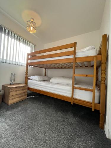 two bunk beds in a room with a window at 141 -Two bed Chalet on Sunbeach Holiday Park - Sleeps 6, pet friendly, FREE pool and entertainment passes included - plus WiFi with bedding and towels included - only 300m from the beach! in Scratby