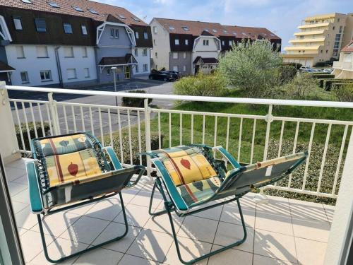 two chairs sitting on top of a balcony at Appartement Anaïs au calme à quelques pas de la mer avec wifi in Merlimont
