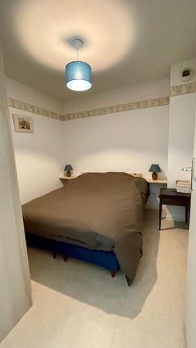 - une chambre avec un lit et une lumière bleue dans l'établissement Appartement Anaïs au calme à quelques pas de la mer avec wifi, à Merlimont