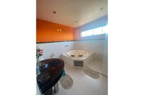 uma casa de banho com um lavatório e uma banheira em Departamento amplio y completo en Área 8 p/ 6 pers em Ciudad del Este