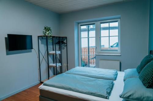 um quarto azul com uma cama e uma televisão em Mountain View Salzburg Apartments em Grödig