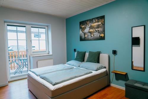 a bedroom with a bed with a blue wall at Mountain View Salzburg - SELF CHECK-IN - Apartments in Grödig